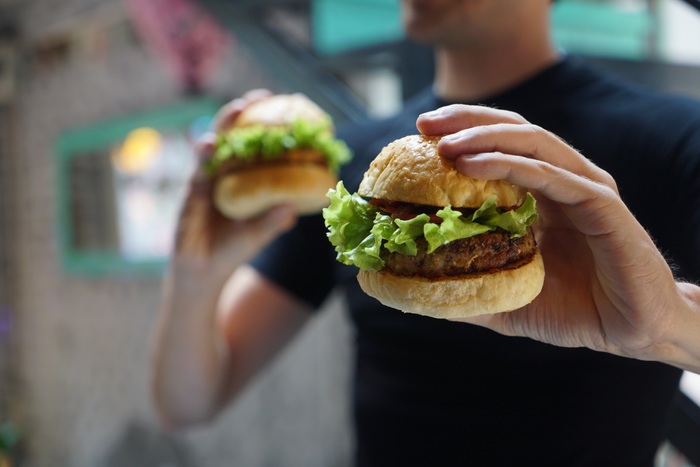 A burger in each hand