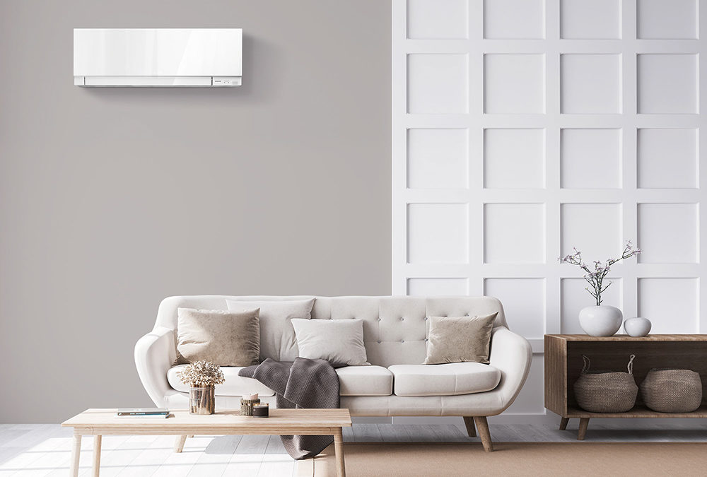 MITSUBISHI HEAT PUMPS SOLD AND INSTALLED BY HEAT AND COOL - HEAT PUMP IN A GREY LIVING ROOM, ABOVE A GREY SOFA