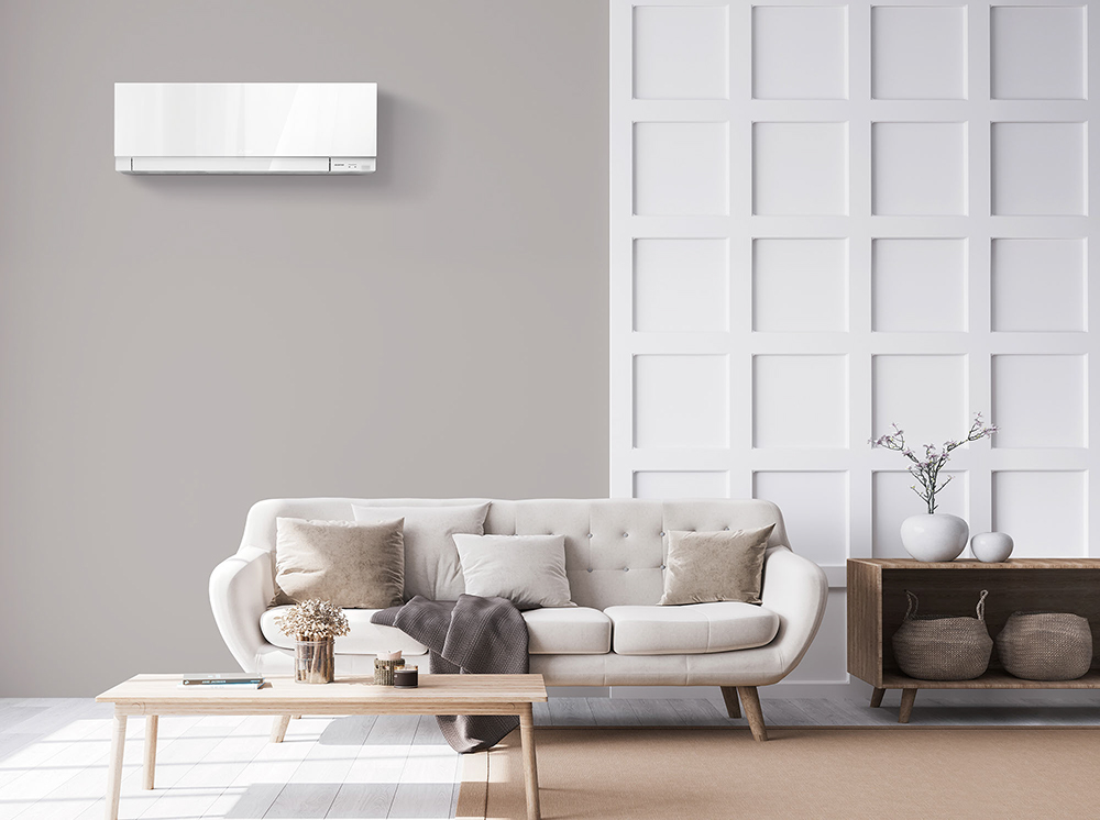 MITSUBISHI HEAT PUMPS SOLD AND INSTALLED BY HEAT AND COOL - HEAT PUMP IN A GREY LIVING ROOM, ABOVE A GREY SOFA